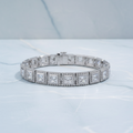 Diamond bracelet on a white surface with green foliage in the background