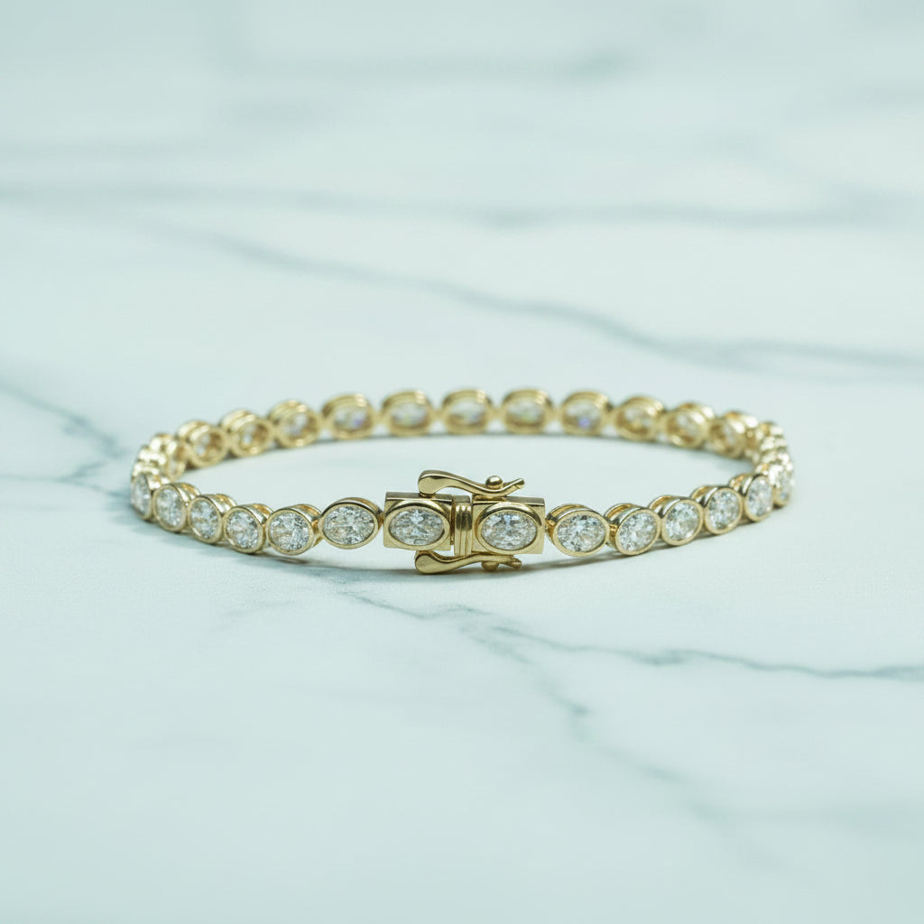 Gold bracelet with clear stones on a light surface with green foliage in the background