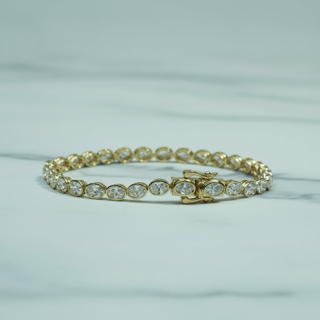Gold bracelet with clear stones on a light surface with green foliage in the background