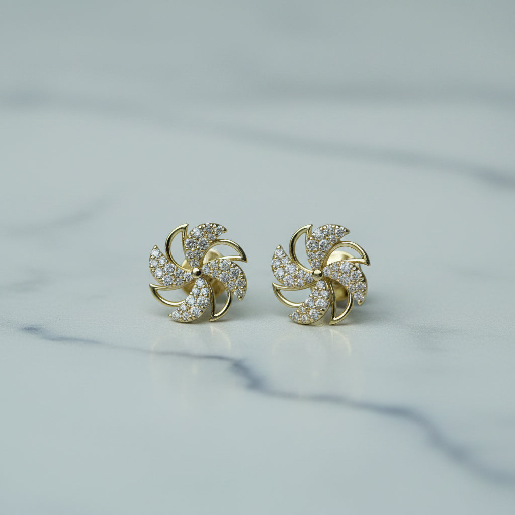 Gold earrings with diamond accents on a light background